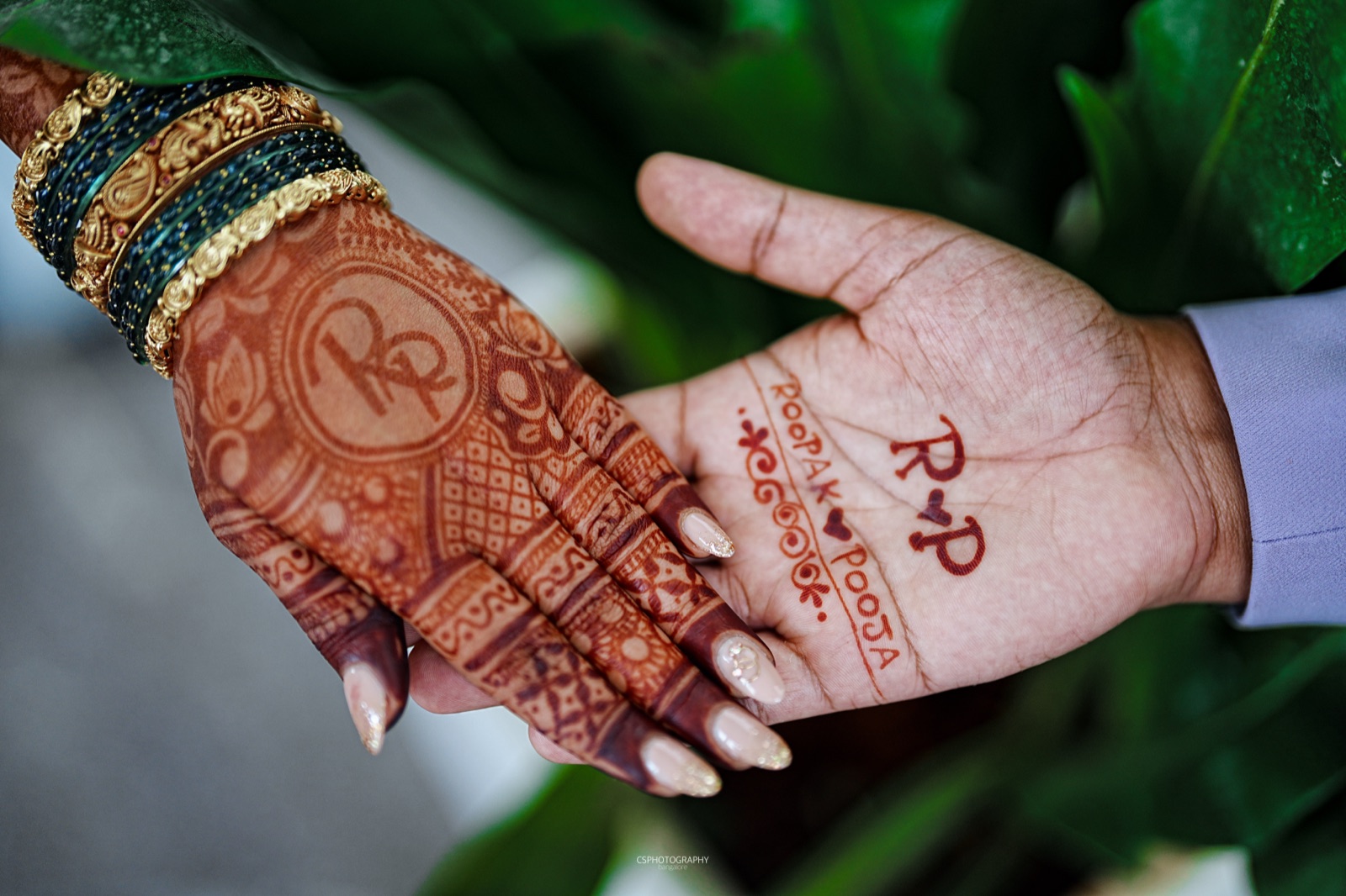 Mehendi hands with Roopak and Pooja written